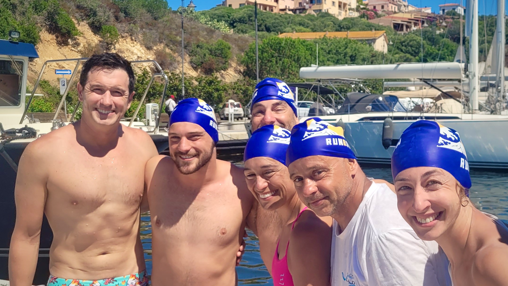 Swimmers celebrating together after successfully completing the Bonifacio Crossing Expedition in Sardinia.